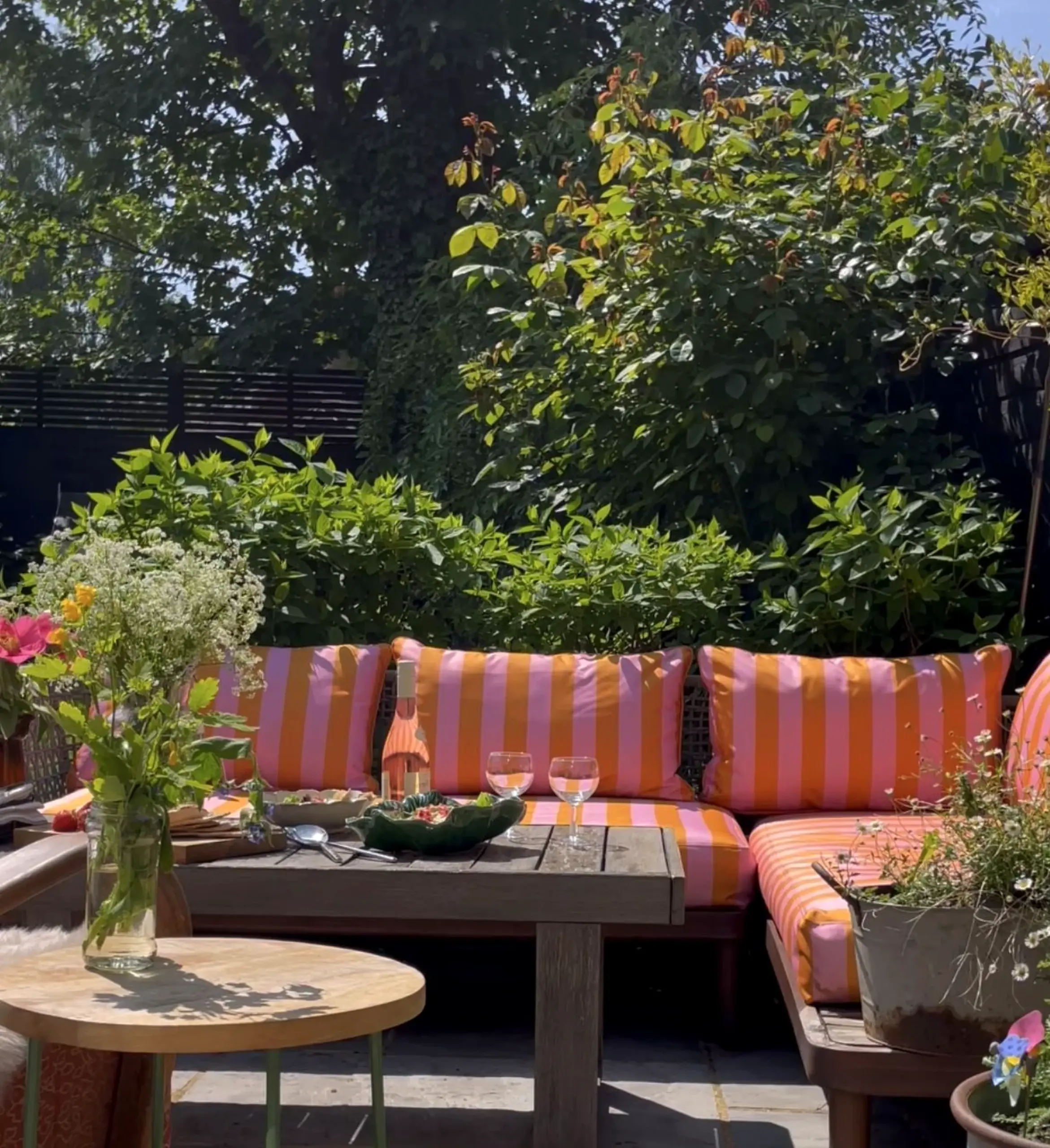 Colorful fireplace area brings contrast to the garden edge, creating a mood that feels pleasantly composed.